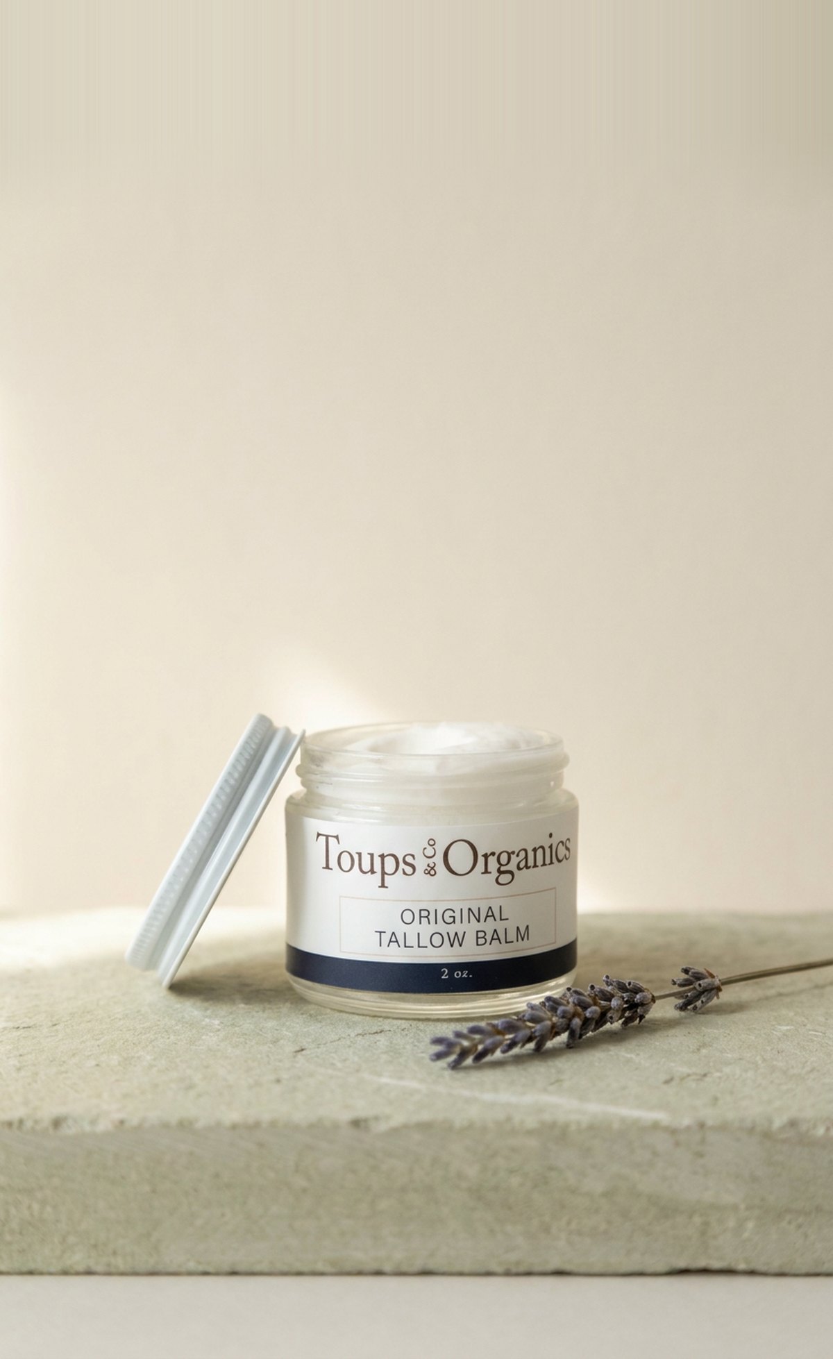 Toups and Co Original Tallow Balm on a stone ledge with dried lavender