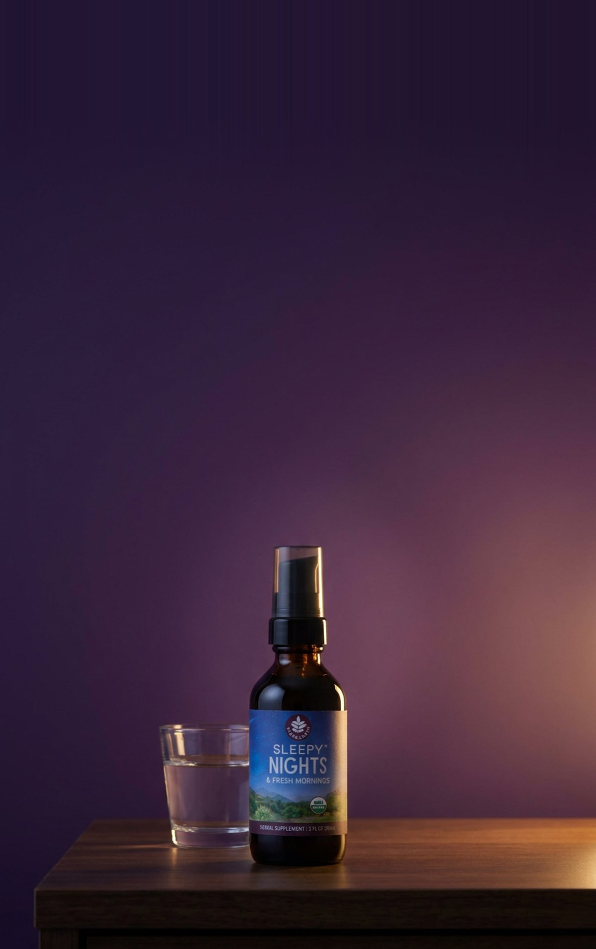 Sleepy Nights pump bottle on a nightstand in a warm night glow